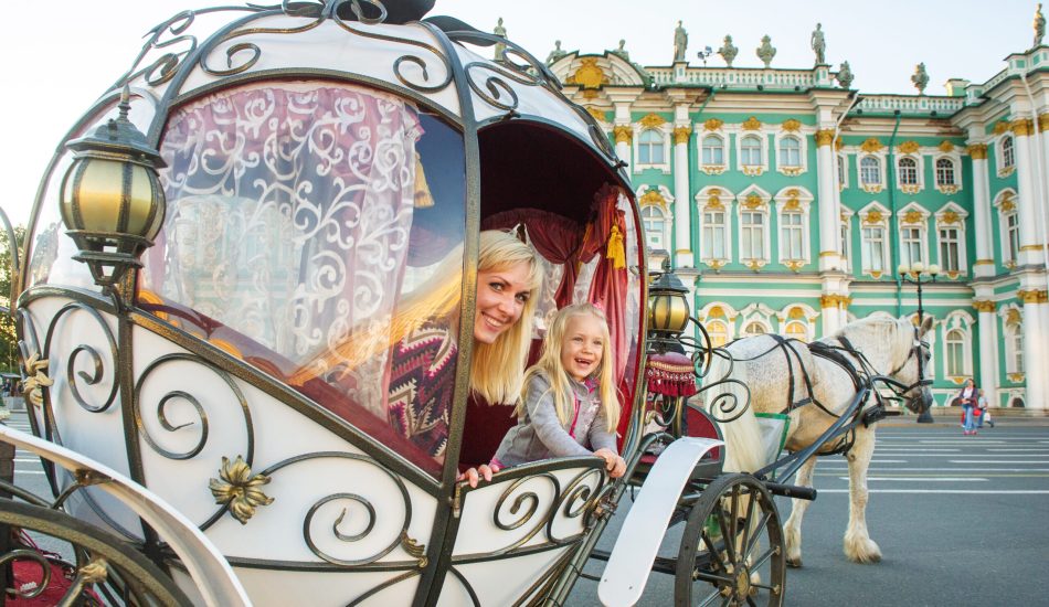 A girl with a child in an old carriage on Palace Square in St. Petersburg.