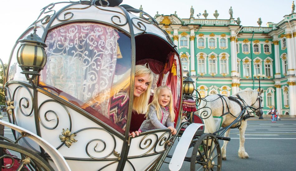 A girl with a child in an old carriage on Palace Square in St. Petersburg A girl with a child in an old carriage on Palace Square in St. Petersburg.