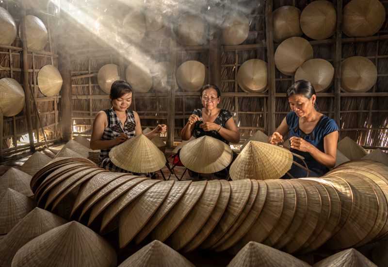 Group of Vietnamese female craftsman making the traditional vietnam hat in the old traditional house in Ap Thoi Phuoc village, Hochiminh city, Vietnam, traditional artist concept
