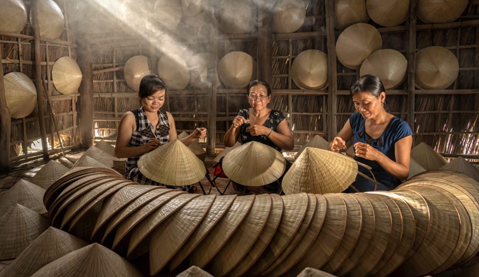 Group of Vietnamese female craftsman making the traditional vietnam hat in the old traditional house in Ap Thoi Phuoc village, Hochiminh city, Vietnam, traditional artist concept
